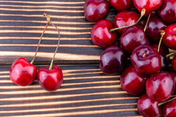 Sweet and ripe red cherry on wooden background. Summer fruit close up image with copy space.
