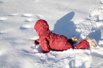 The child crawls joyfully in the snow - 481367030