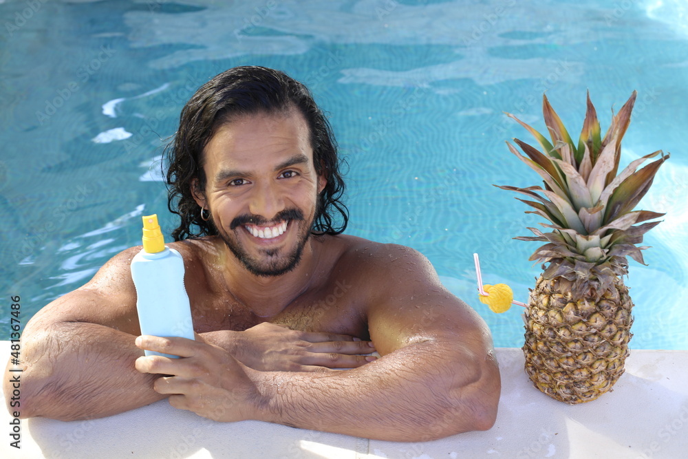 Wall mural Man with beautiful olive skin using sun tan lotion in swimming pool