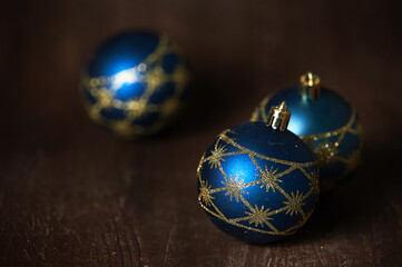Blue Christmas tree toys on a dark background lie on a dark table