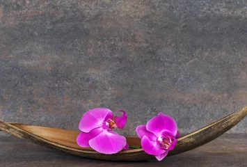 Foto auf Leinwand Orchideenblüten in einer Palmblattschale. © Racamani