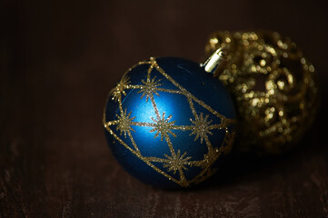 Blue and gold Christmas tree toys on a dark background lie on a dark table