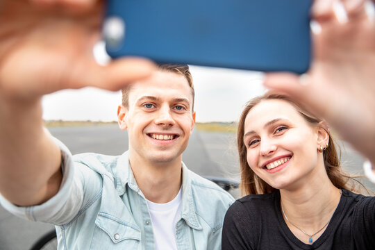 Happy couple taking a selfie together and smiling at camera