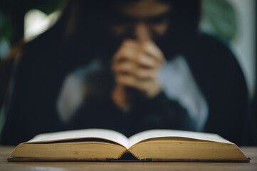 Christian life crisis prayer to god. Women Pray for god blessing to wishing have a better life. Hands praying to god with the bible. believe in goodness. Holding hands in prayer on a wooden table.