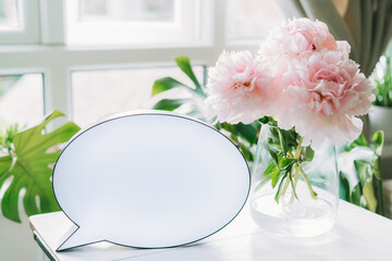 Creative romantic composition of lightbox with copy space and bouquet of pink peony flowers in the vase on the white table on light interior background. Template greeting card text design.