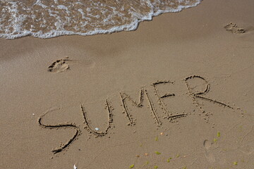 The inscription on the sand Summer symbolizes a summer vacation at the sea