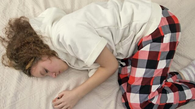 Distressed introvert teen 13s girl child lies on bed at home suffer from school discrimination or bullying problems. Unhappy sad teenager stressed with psychological troubles. Loner, outcast concept.
