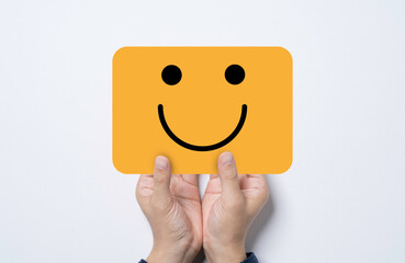 Hand holding and give yellow card with smile face for positive thinking mindset and excellent...
