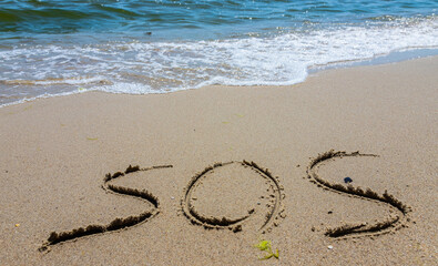 The inscription on the sand at the beach sos