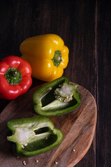 Peppers on wooden table, vertical.