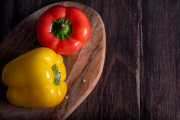 Fresh red, yellow and green peppers on wooden table, horizontal.