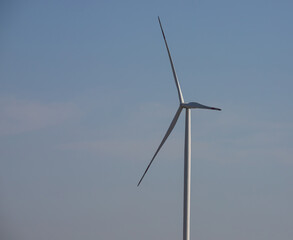 wind mill or also wind-turbine on wind farm in rotation to generate electricity energy on outdoor...