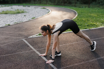 A fitness woman doing a stretching exercise stretches her legs. Women stretch to warm up before...