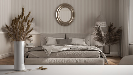 White table top or shelf with straws, dry plants, ornament, ears, sheaf, branch in vase, over classic bedroom with double bed, wallpaper and woodwork, classic minimal interior design