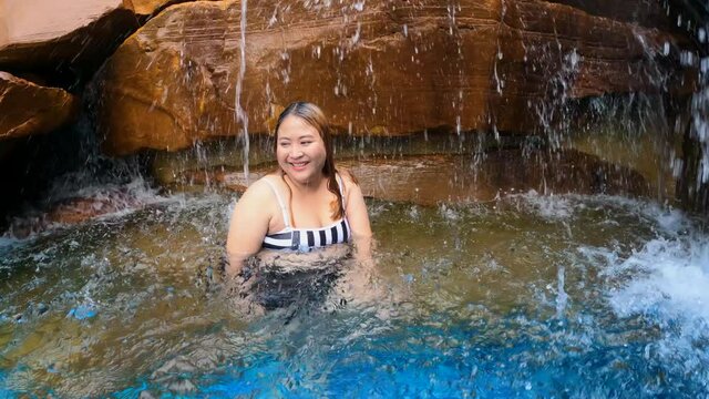 Happy Asian family relaxing in swimming pool. Cute asian boy and fat mother enjoy swimming.