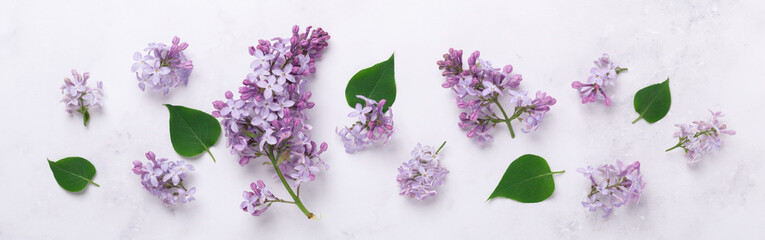 Fototapeta na wymiar Extra long banner with lilac flowers on stone background. Mothers day, womens day concept. Flat lay, top view