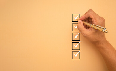 Checklist concept. White marking on checklist box isolated on an orange background.