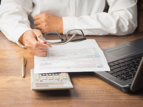 Businessman using a tax form to complete individual income tax payment form.