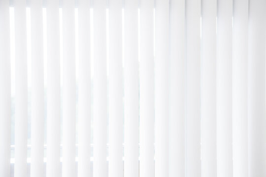 wei&szlig;e jalousie mit vertikalen lamellen als sichtschutz und gegen blendung durch sonnenlicht