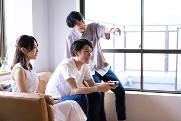 家でテレビゲームをする若い男女