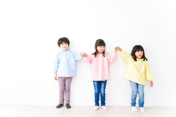 Obraz premium 壁に並ぶ3人の幼稚園児