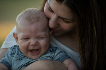 Niño bebé riendo, mirando y sonriendo con su mamá