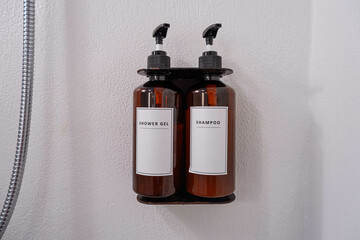 Toiletries brown pump bottle in a luxury hotel, shower gel, shampoo in bathroom wall. Copy space.