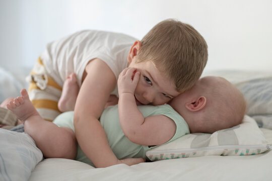 Ni&ntilde;os beb&eacute;s hermanos jugando en la cama de sus padres abrazados