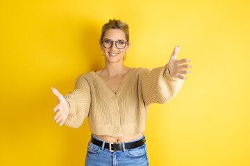 Young beautiful woman wearing casual sweater over isolated yellow background looking at the camera...