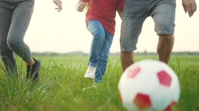 happy family playing soccer with ball in the park. children playing football in the park. happy family a kid dream concept. father plays with small kid in fun a ball in nature in summer