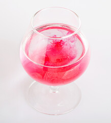 Drops of pink paint in a glass of water