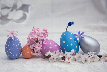 Colorful pastel painted eggs in a row combined with spring flowers. place for text. Easter decor