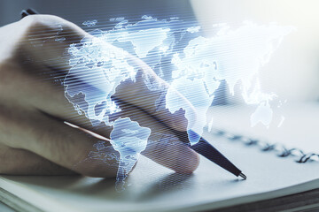 Double exposure of abstract digital world map and man hand writing in notepad on background, big data and blockchain concept