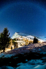 snowy landscape in the mountains at night with stars