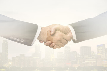 Double exposure of handshake two businessmen on modern skyscrapers background, research and strategy concept
