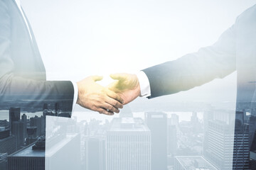 Handshake of two businessmen on modern city skyline background, deal and partnership concept....
