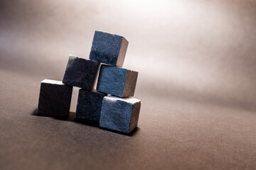  Stones for cooling drinks in the form of a pyramid stand on a grey background. Stones for whiskey. High quality photo