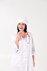 A female therapist with a stethoscope as if with a microphone in the clinic on a white background