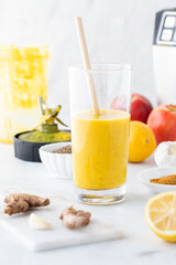 A freshly mixed and poured turmeric detox elixir in a glass, ready for drinking.