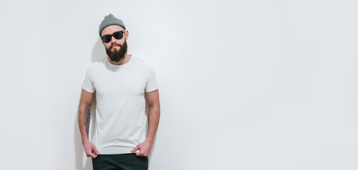 Young bearded hipster guy wearing white blank t-shirt. Mock-up for print. T-shirt template.