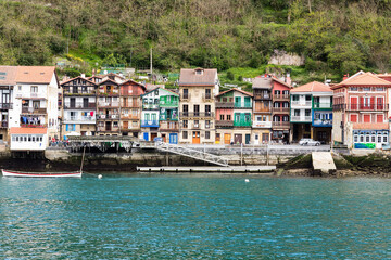 Fototapeta premium Jolies façades colorées d'un village espagnol devant le quai d'un petit port. Pasai Donibane, Guipuscoa Espagne