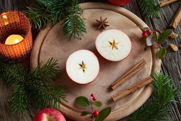 Obraz na płótnie Canvas Christmas decoration with a halved apple, cinnamon, wintergreen, star anise and fir