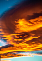 A dusk image of golden clouds swooping across the skies of Marbella during sunset