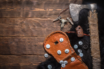 A magic runes and battle axe on the table background.