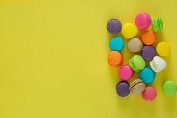 Sweet colorful macaroons on yellow background,Sweet and colorful french macaroons or macaroon on yellow background, Dessert eating with tea or coffee.
