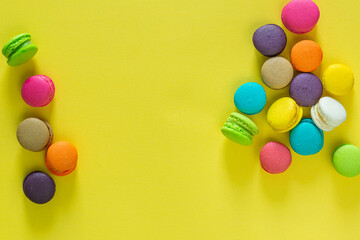 Sweet colorful macaroons on yellow background,Sweet and colorful french macaroons or macaroon on yellow background, Dessert eating with tea or coffee.