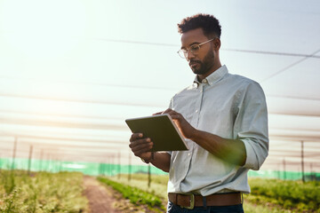 It's the only life for him. Cropped shot of a handsome young male farmer using a tablet while working on his farm.