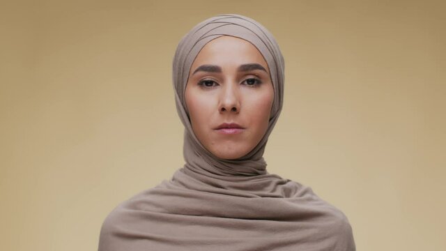 Studio Portrait Of Young Serious Muslim Arab Woman Wearing Traditional Headscarf Looking At Camera