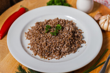 buckwheat a portion in a cafe boiled side dish in a white plate on a wooden background