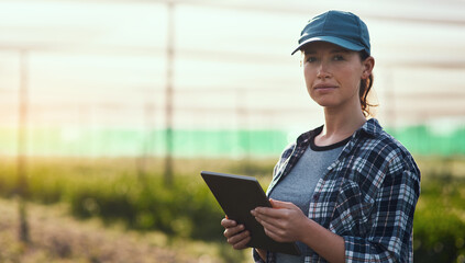 Managing a farm is serious business. Cropped portrait of an attractive young female farmer using a...